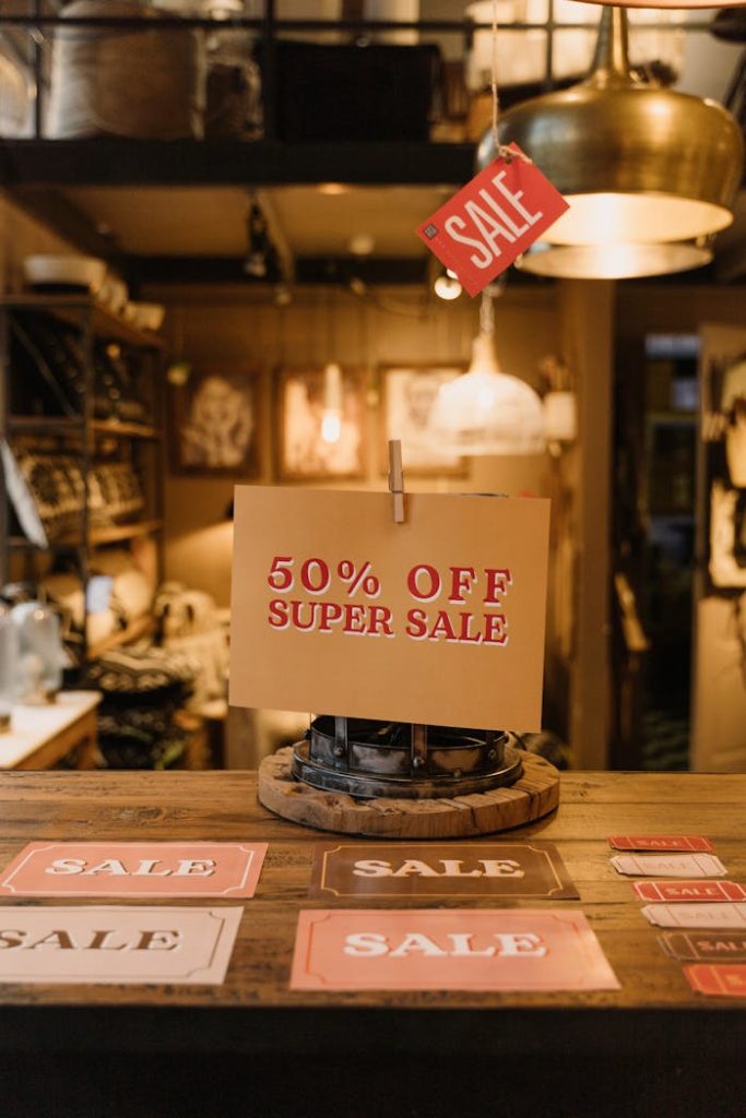 A cozy retail store features a 50% off super sale setup with signs on display.